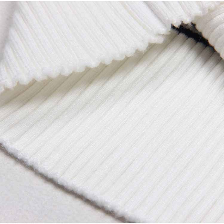 Close-up of a white ribbed knit midi dress showcasing the soft and textured fabric