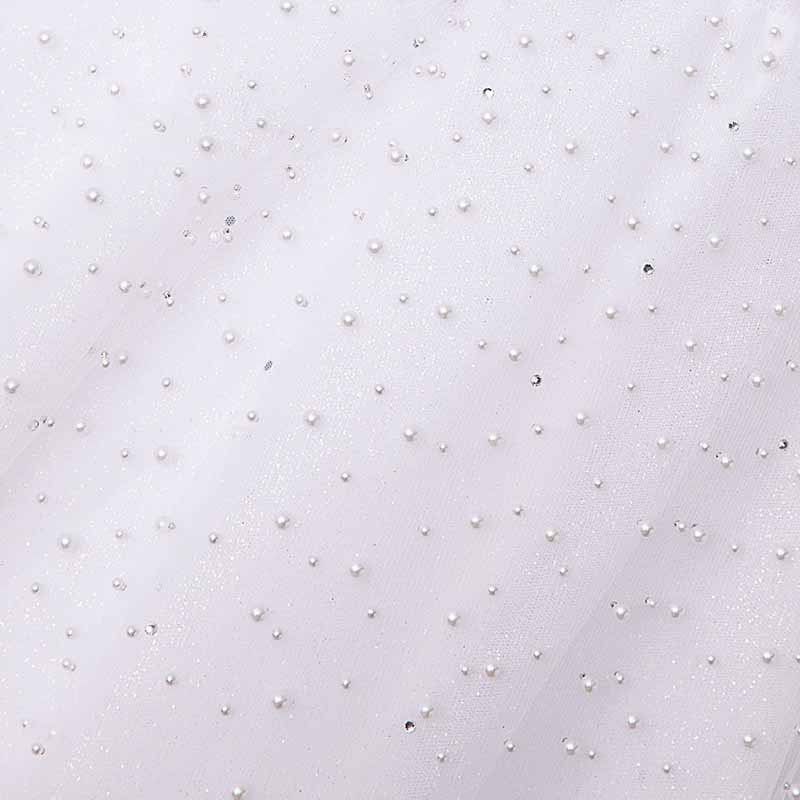 Close-up of a sweetheart tulle wedding dress adorned with delicate pearl embellishments