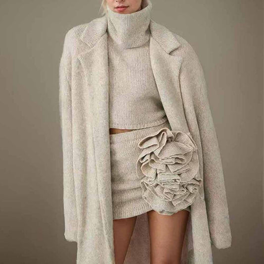 Stylish three piece women's sweater set featuring a cropped top, skirt, and long coat in soft beige tones