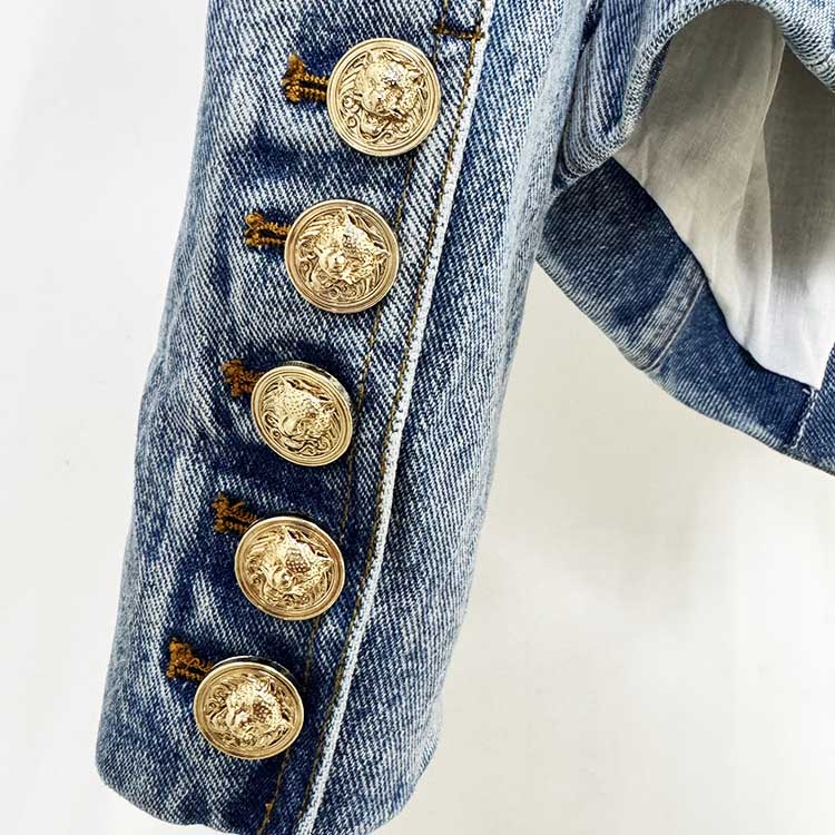 Close-up of women's belted denim jacket showcasing detailed gold buttons on the sleeve