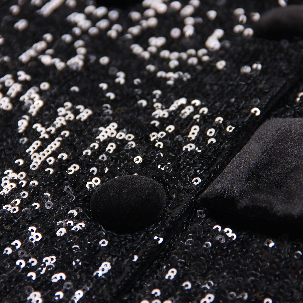 Close-up of women's black sequin blazer showcasing shimmering sequins and velvet details