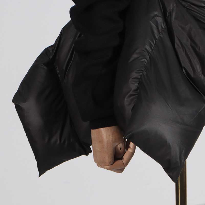 Close-up of women's black winter coat with belt featuring a cozy puffer design and stylish detailing