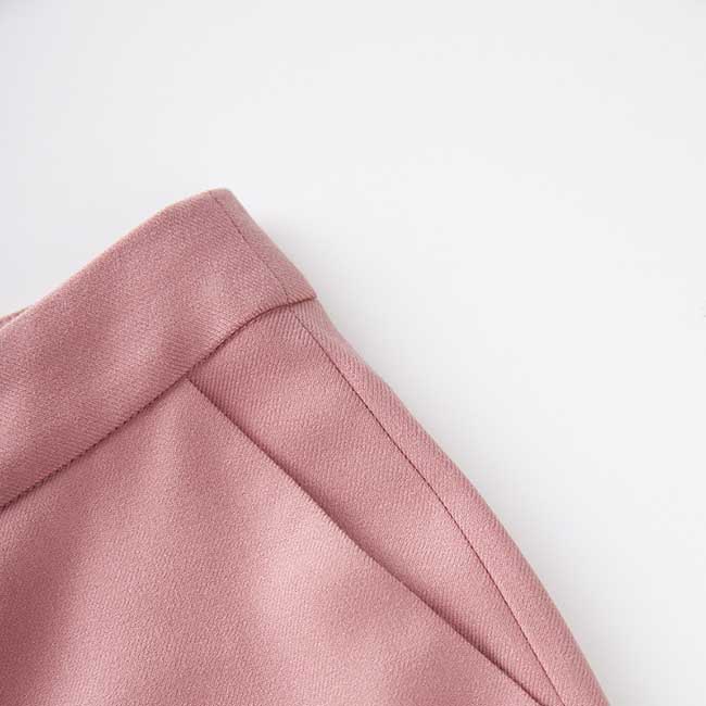 Close-up of women's pink pantsuit for formal events with tailored seams and soft fabric texture