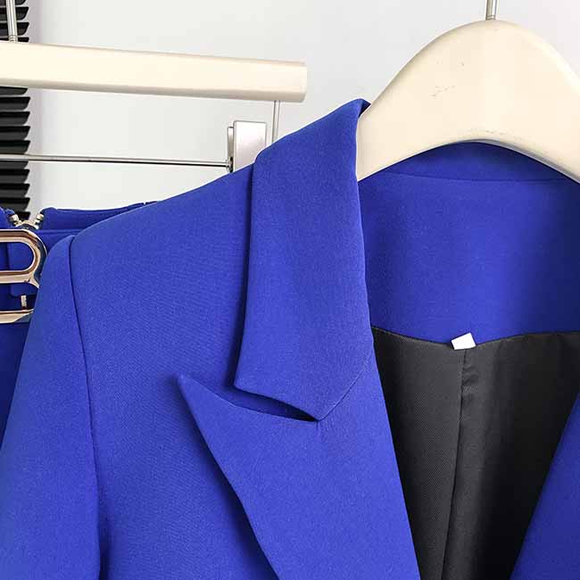 Close-up of a vibrant blue one-button bell-bottom suit for women showcasing the tailored lapel and pocket design