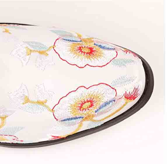 Close-up of women's embroidered western cowboy boots featuring floral designs and a pointed toe