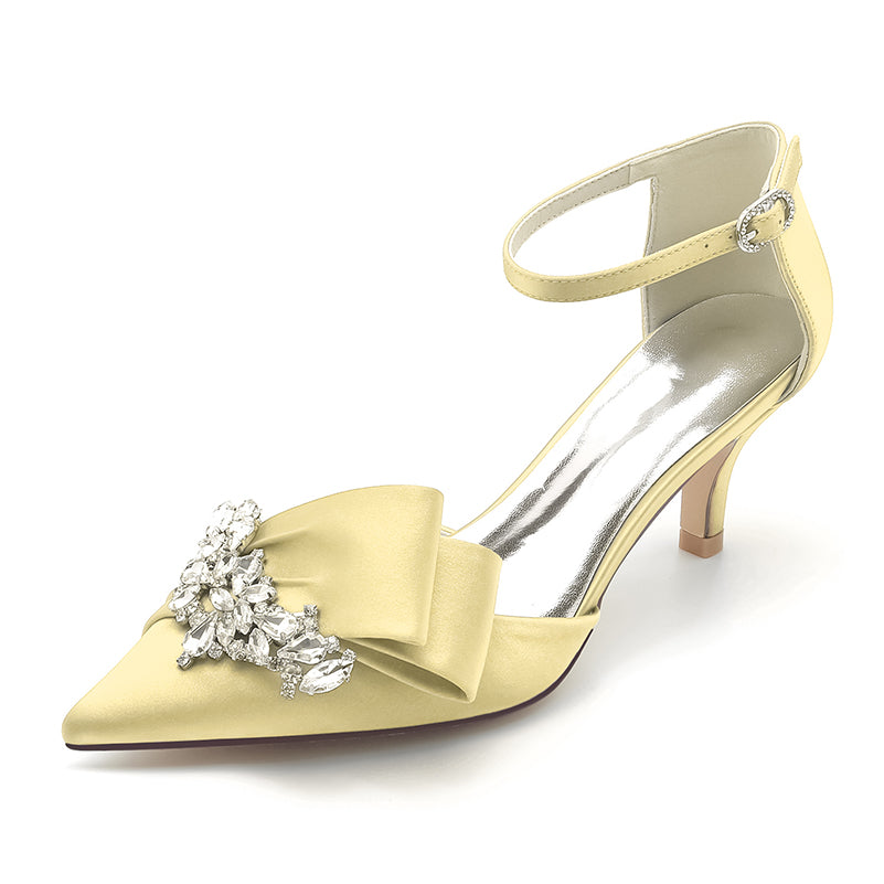 Gold high-heeled shoe with bow and crystal embellishments on a white background