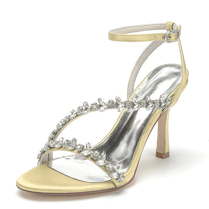 Silver high-heeled sandal with decorative straps on a white background