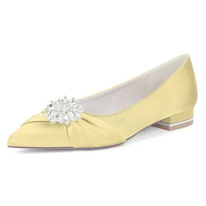 Yellow shoe with a decorative brooch on a white background