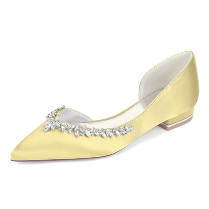 Yellow pointed-toe shoe with crystal embellishments on a white background