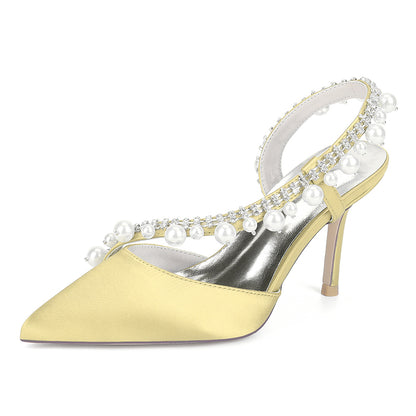 Yellow high-heeled shoe with pearl embellishments on a white background