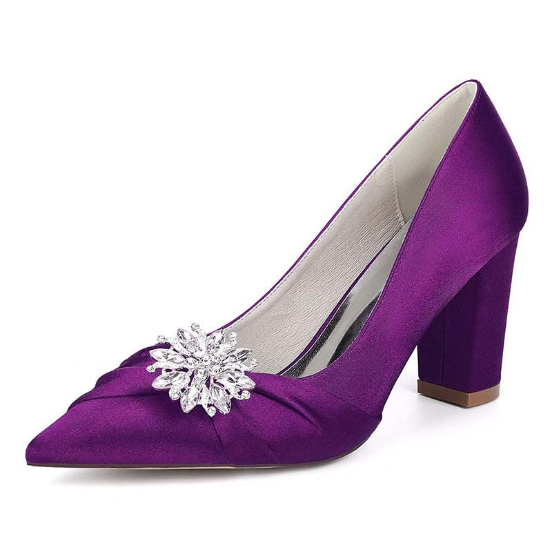 Purple high-heeled shoe with a decorative brooch on a white background
