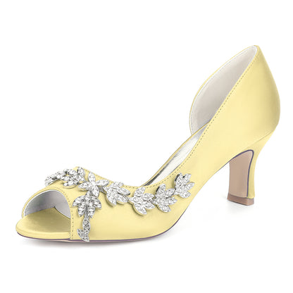 Yellow high-heeled shoe with decorative elements on a white background