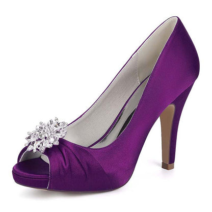 Purple high-heeled shoe with a decorative flower on a white background