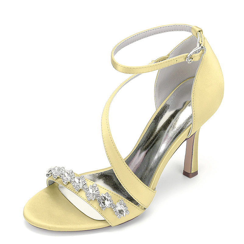 Yellow high-heeled sandal with crystal embellishments on a white background