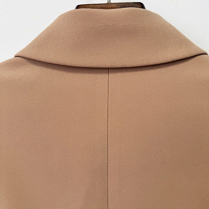 Close-up of the back of a camel-colored coat or jacket on a hanger, showing a high folded collar and a central seam.
