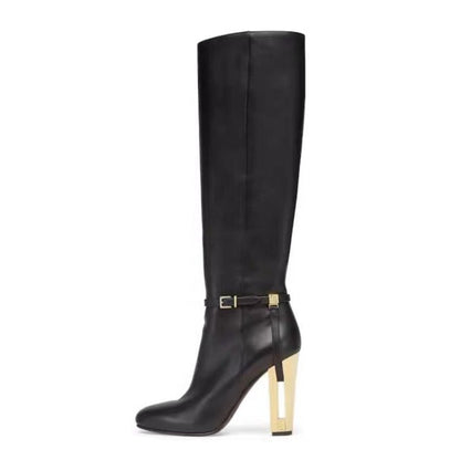 Black knee-high boot with a gold heel on a white background