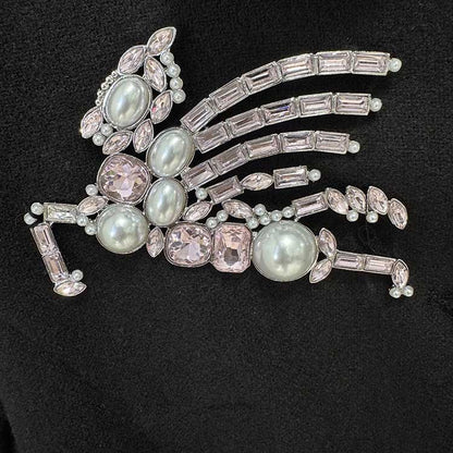 Close-up of embellishment on women's winter wool coat featuring intricate gem design