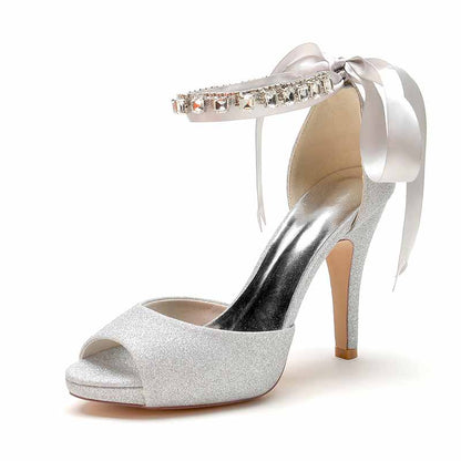 Ankle strap bridal pumps in silver glitter with a rhinestone detail and ribbon for elegant wedding shoes