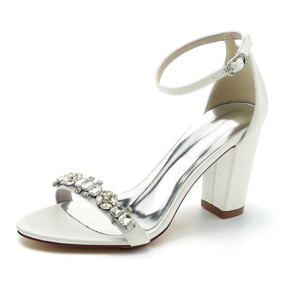 Elegant white S&DCo. ankle strap dress sandals for weddings with a jeweled embellishment and block heel