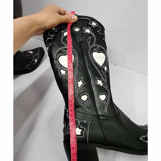 Black embroidered cowgirl boots for women with intricate designs and measurement tape for sizing