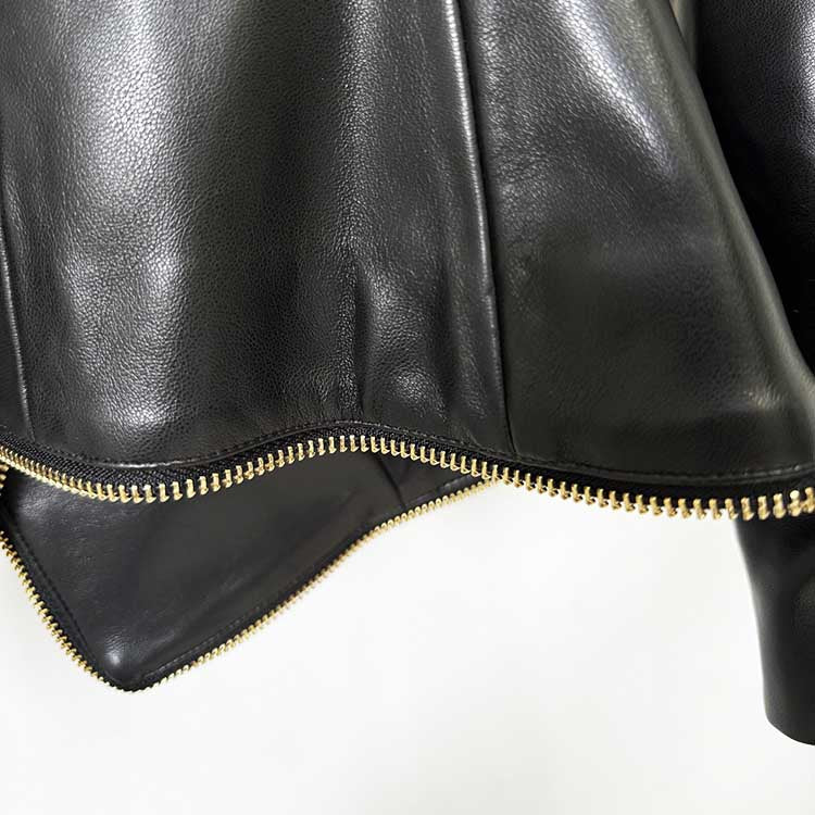 Close-up of a black fitted leather jacket with zippers showcasing high-quality stitching and a sleek design