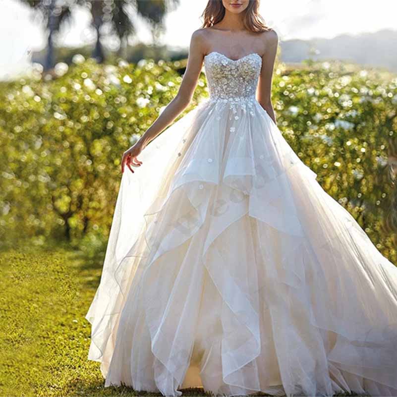 Elegant boho wedding dress with ruffles, featuring a strapless design and a flowing skirt