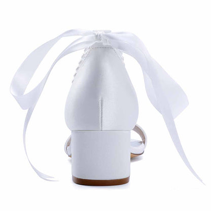 Elegant white lace-up dress sandals for brides with satin finish and decorative ribbon ties