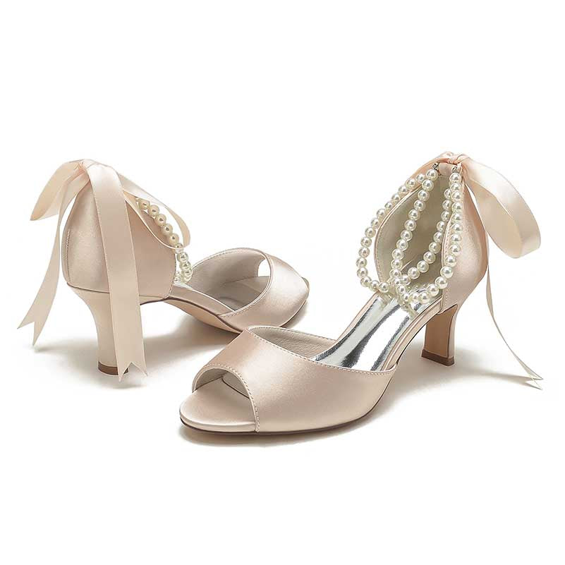 Elegant low heel satin bridal shoes with pearl embellishments and ribbon accents for weddings