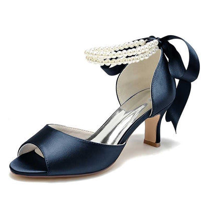 Navy low heel satin bridal shoes with pearl accents and a stylish ankle ribbon