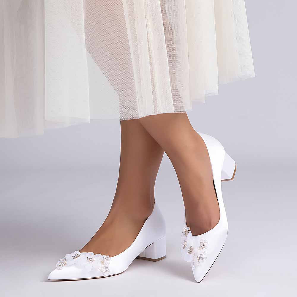 Elegant white bride shoes with flower appliques, perfect for weddings and formal events