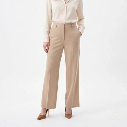 A woman modeling a light beige satin button-down shirt and matching beige wide-leg trousers, paired with brown pointed-toe heels, against a plain white studio background.