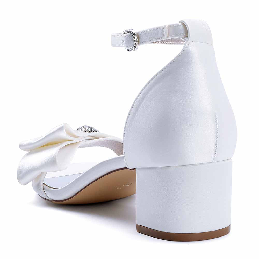 Elegant white chunky heel wedding sandals with a floral design and ankle strap for bridal occasions