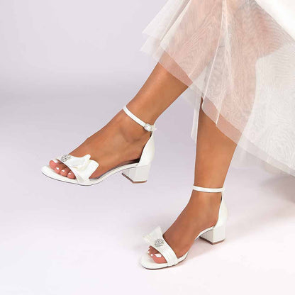 Elegant chunky heel wedding sandals in white with a delicate bow detail for bridal style