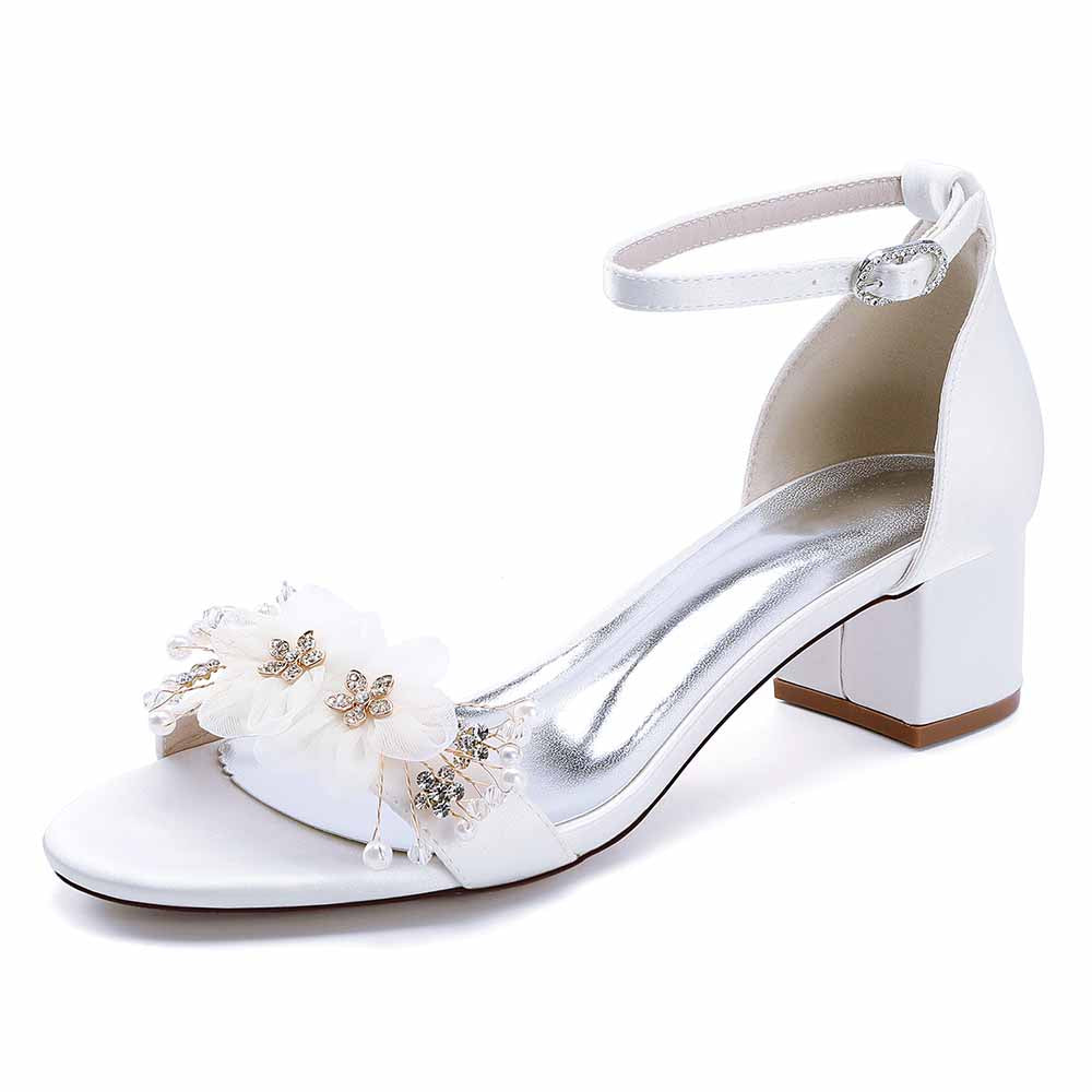 Elegant white chunky heeled sandals for brides featuring floral embellishments and an ankle strap