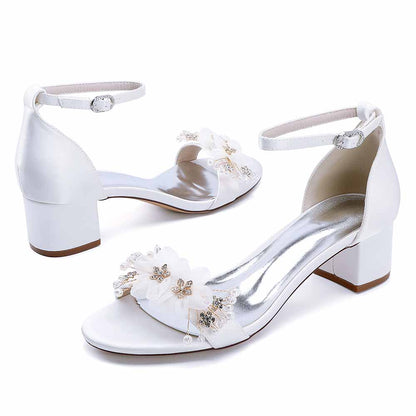 Elegant white chunky heeled sandals for brides with floral embellishments and ankle strap