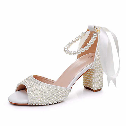 Elegant S&DCo. chunky lace up bridal shoes adorned with pearls and a ribbon for a stylish wedding look.