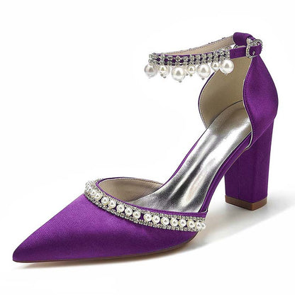 Purple high-heeled shoe with pearl and crystal embellishments on a white background
