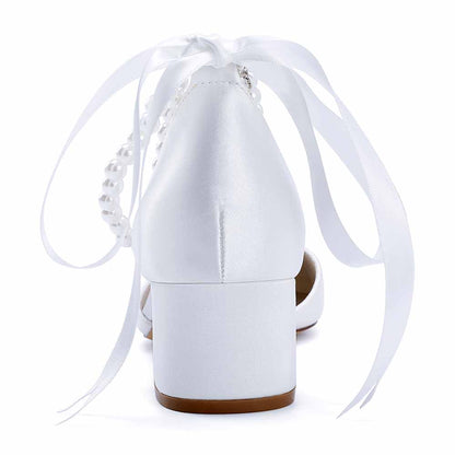 Elegant closed toe wedding heels for bride with ribbon and pearl detailing in white