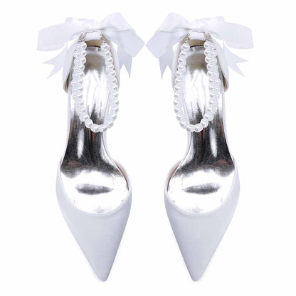 Elegant closed toe wedding heels for bride featuring pearl detailing and satin bow for a chic look