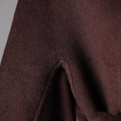 Close-up of a collarless double belted cashmere coat in a rich brown fabric