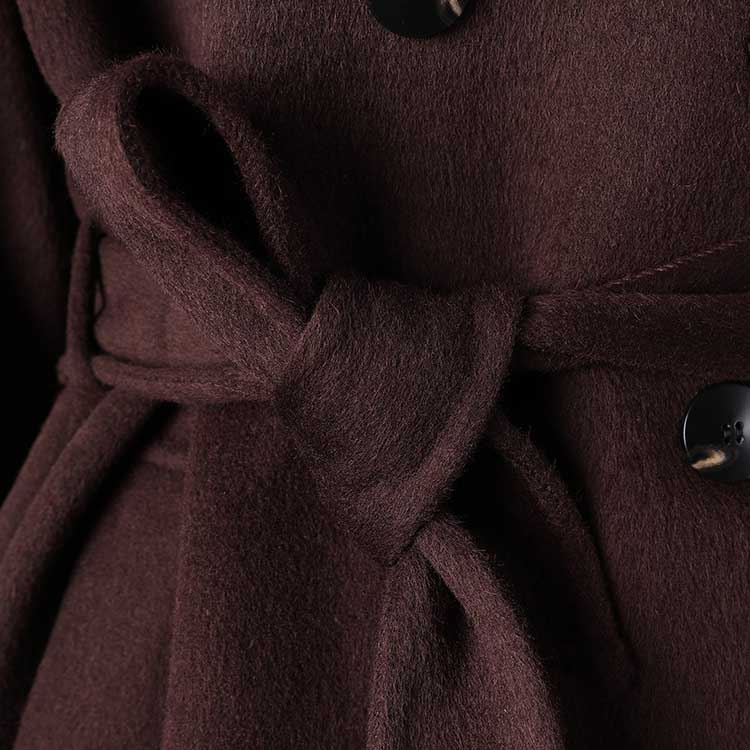 Close-up of collarless double belted cashmere coat in rich brown with elegant tie and button details