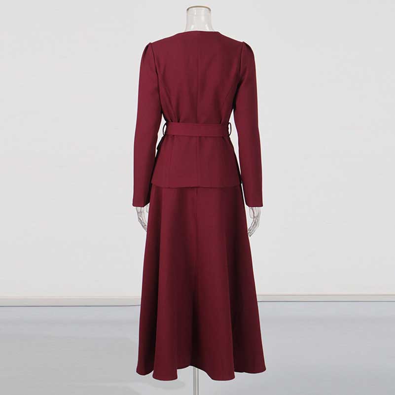 Back view of collarless women's midi skirt set in burgundy with a fitted blazer and flowing skirt