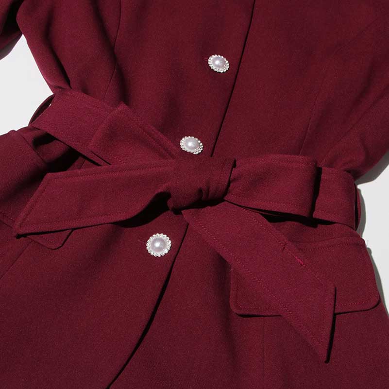 Collarless women's midi skirt set in burgundy with a stylish belt and decorative buttons.