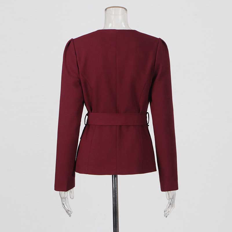 Back view of collarless women's midi skirt set in burgundy with belt detail and structured sleeves