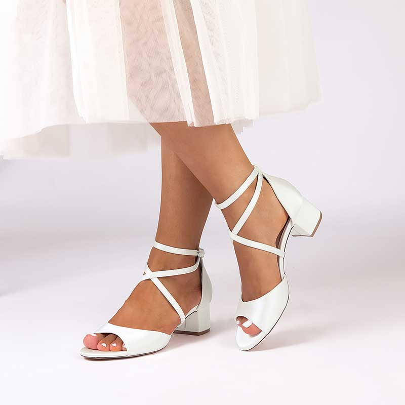 White criss cross satin block heel sandals with a stylish design and comfortable fit