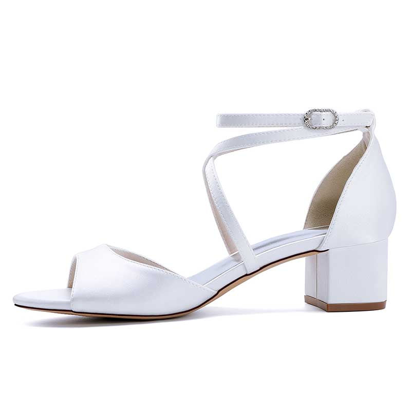 Elegant criss cross satin block heel sandals in white with an ankle strap for stylish occasions.