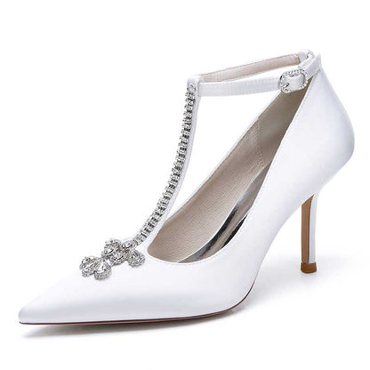 Elegant white crystal ankle strap wedding heels with pointed toe and decorative embellishments