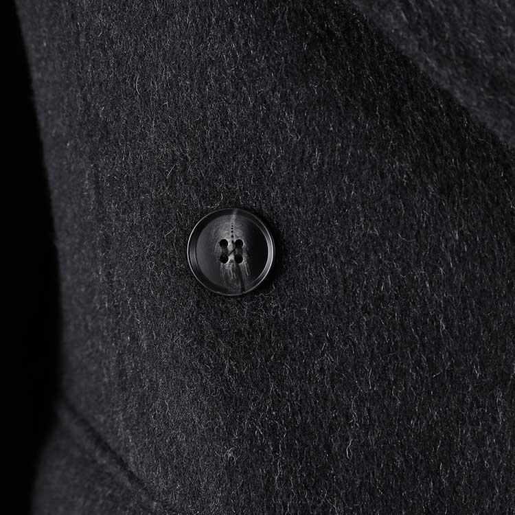 Close-up of a double belted wool coat black featuring a stylish button detail