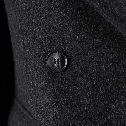 Close-up of a double belted wool coat black featuring a stylish button detail