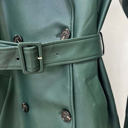 Close-up of a double breasted faux leather trench coat in green with stylish belt and buttons